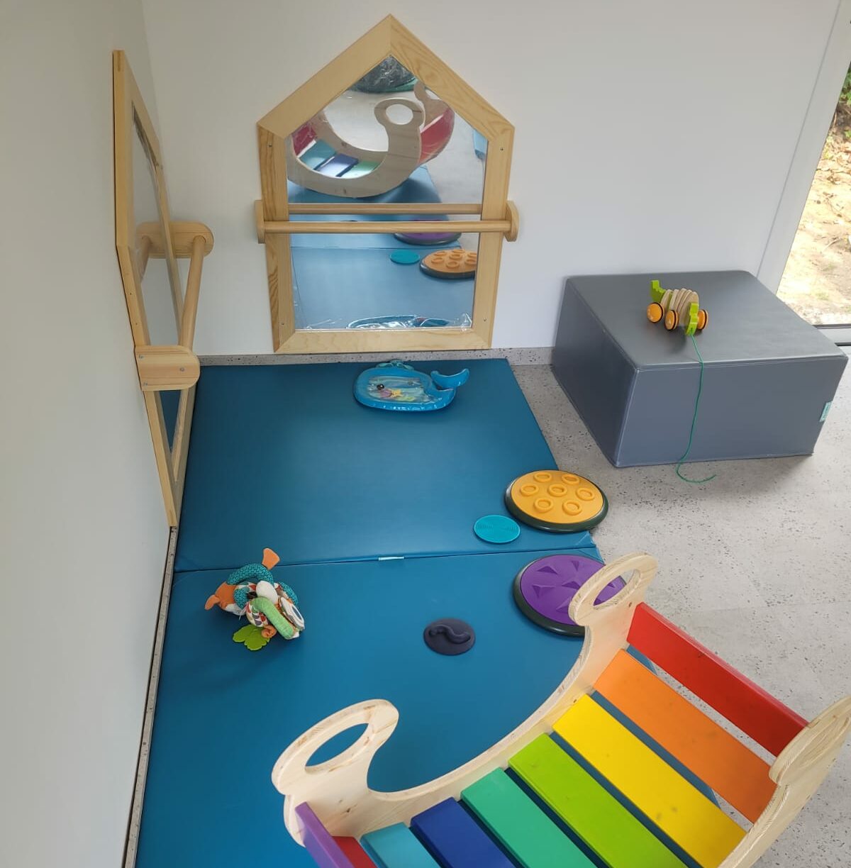 Espace bébé avec miroir et jeux sensoriels